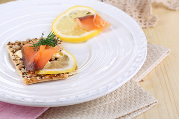 Salmon sandwich on plate  on wooden table close-up