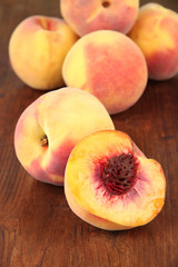 Fototapeta na wymiar Ripe sweet peaches, on wooden background