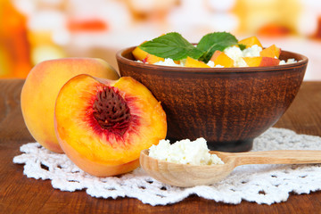 Sour cheese and pieces of fresh peach,on wooden table,