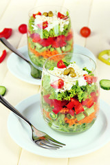 Tasty salad with fresh vegetables on wooden table