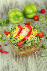 Tasty salad with fresh vegetables on wooden table