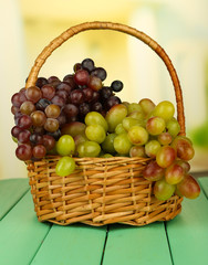 Fresh grape on wicker mat on bright background