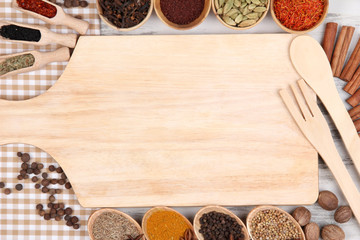 Various spices and herbs with empty wooden board