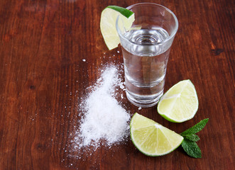 Tequila in glass on wooden table close-up