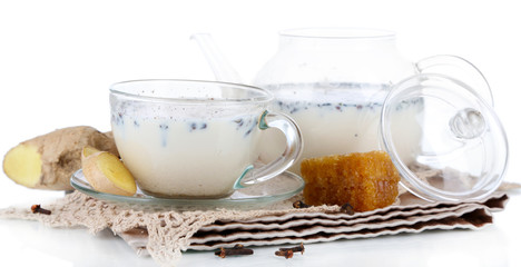 Teapot and cup of tea with milk and spices