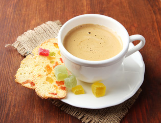 Cup of tasty coffee with Italian biscuit, on wooden background