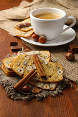 Cup of tasty coffee with Italian biscuit, on wooden background