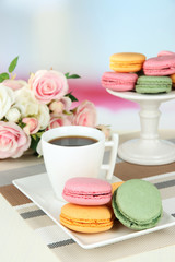 Coffee and macaroons on table on light background