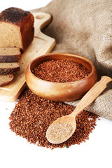 Buckwheat groats in bowl and wooden spoon closeup