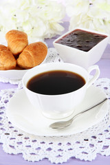 Tasty croissants and cup of coffee on table close-up