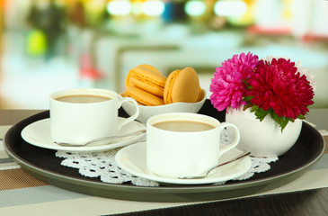 Cups of coffee on tray on table in cafe