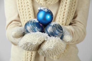 Female hands  in mittens Christmas tree balls,
