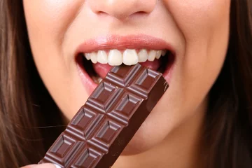 Papier Peint photo Lavable Bonbons Closeup of woman eating chocolate