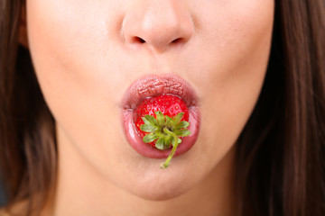 Closeup of woman eating strawberry in chocolate