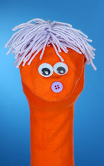 Cute sock puppet on blue background