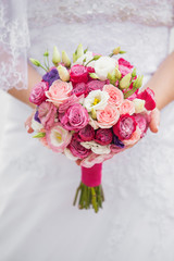 wedding bouquet of roses and eustoma in the hands of the bride