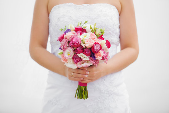 wedding bouquet of roses and eustoma in the hands of the bride