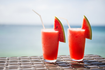 Two fresh watermelon juices on a tropical beach
