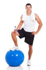muscular man with water bottle and fitness ball