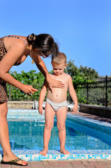 Young mother applying sunscreen to her son