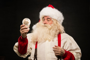 Fototapeta na wymiar Santa Claus holding snow globe