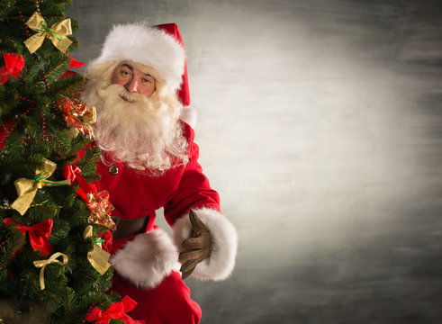 Santa Claus standing near Christmas tree