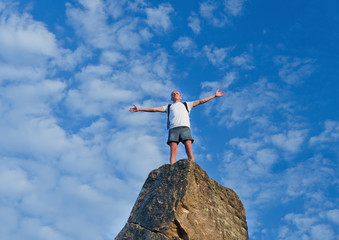 Obraz premium Man celebrating reaching the top of a mountain