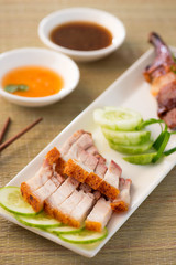 chinese roast pork close up shot served with chilli sauce