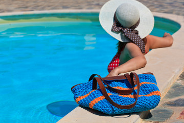 Fototapeta na wymiar Woman relaxed at the pool with beach bag