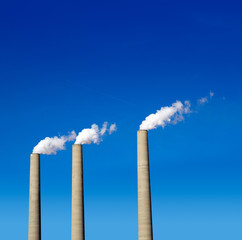 Chimney white smoke three in a row on a blue sky