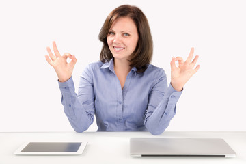 Business woman is sitting in front of a laptop and a tablet