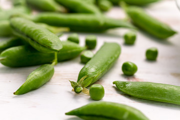 Fresh green peas on a white table