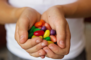 Caramelos de colores en las manos de niño