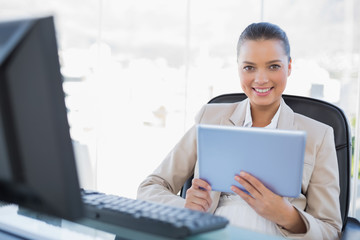 Cheerful sophisticated businesswoman holding tablet pc