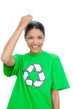 Smiling model wearing recycling tshirt holding light bulb above