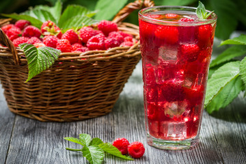 Juice of fresh raspberries served with ice in a glass