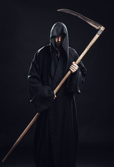 Naklejka premium death with scythe standing in the dark
