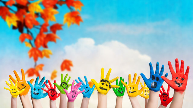 angemalte Kinderhände vor Herbsthintergrund