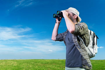 Explorer looking through binoculars outdoors