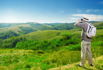 Fototapeta na wymiar Explorer watching beautiful landscape through binoculars