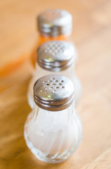 salt and pepper in shaker glass bottle on wood table