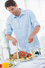 Attractive man carving the dinner