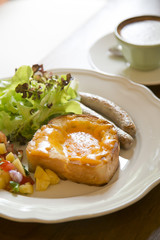 Fried egg on bread with sausage,salad and coffee