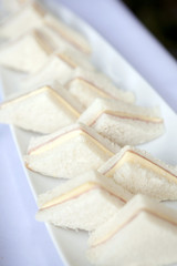 Ham cheese sandwiches on white plates in party