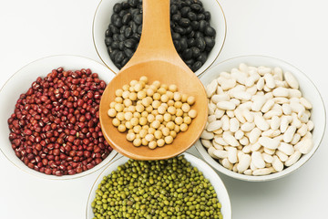 variety beans in bowls and wooden soup spoon