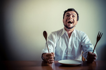 young stylish man with white shirt eating in mealtimes
