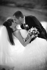Black and white portrait of newly married couple kissing
