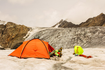 The climber has a rest lying in tent on glacier