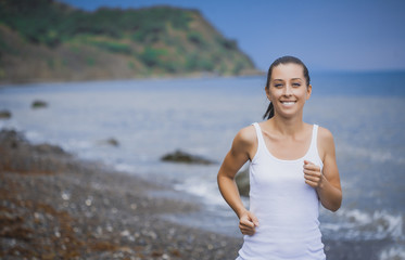 athlete girl on morning jog on the beach