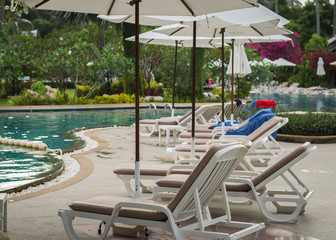 couches with umbrellas around the pool